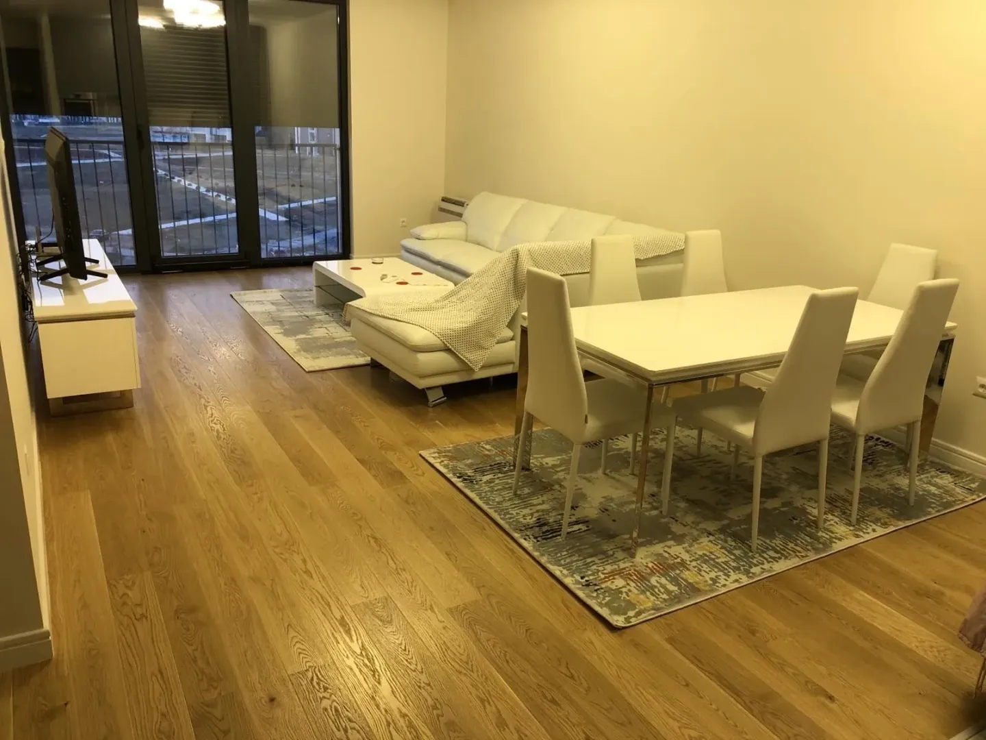 Bright living room with a dining table and a leather sofa.