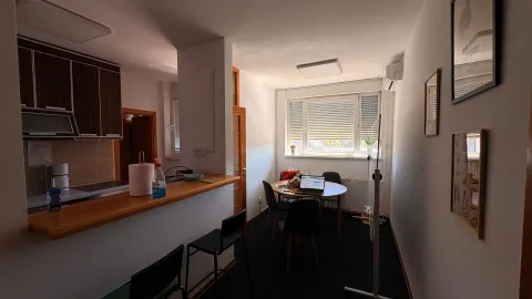 Small kitchen with a breakfast bar and a dining table by the window. - image 5