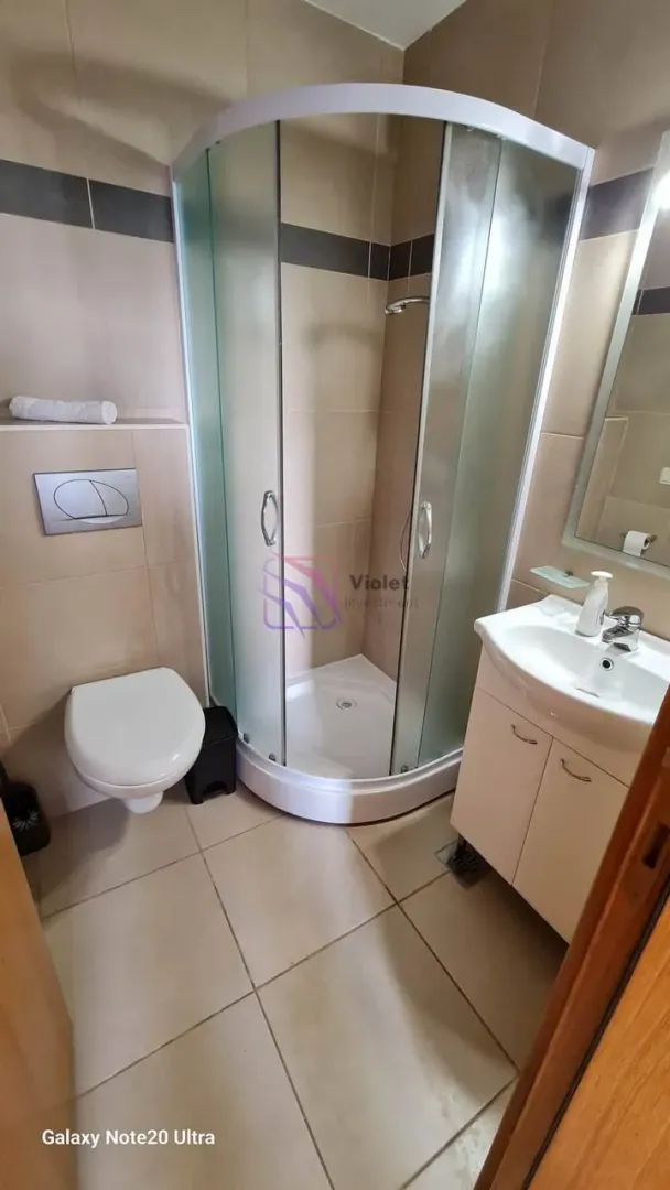 Kupatilo opremljeno tuš kabinom, umivaonikom i wc šoljom.