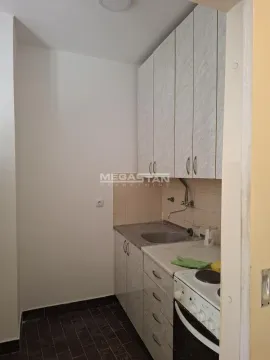 Small kitchen with a sink, cabinets, and a stove. - image 5