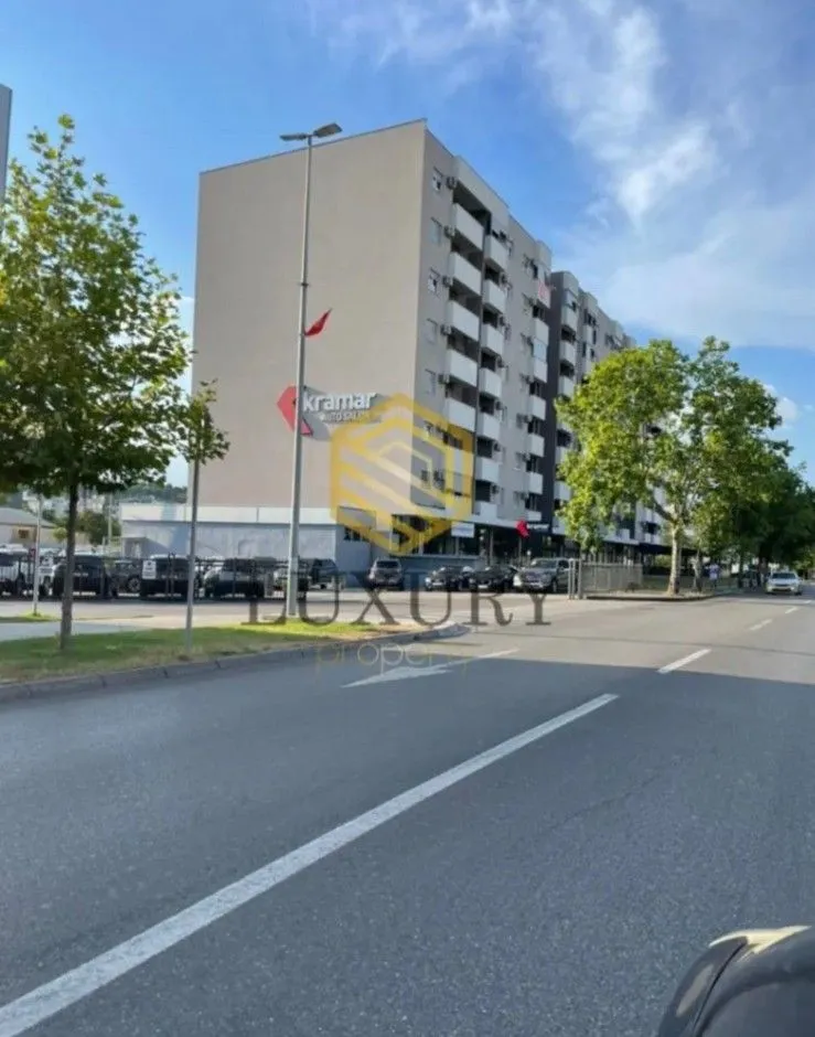 Exterior view of an apartment building with a street in the foreground.