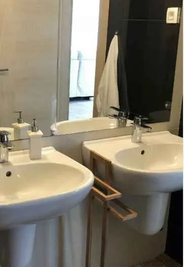Svijetlo kupatilo sa umivaonikom i velikim ogledalom.