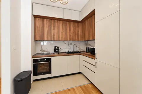 Modern corner kitchen with wooden elements and built-in appliances. - image 6