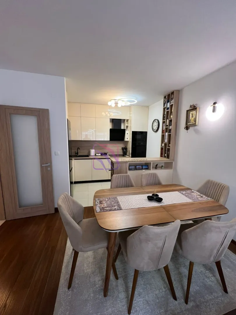 Dining area with a table and chairs and a view of the open kitchen.
