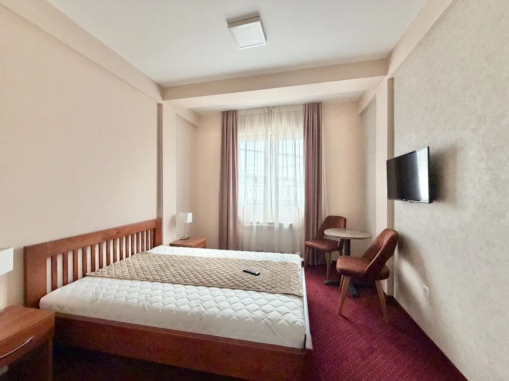 Bedroom with a double bed, TV, and a dining corner.