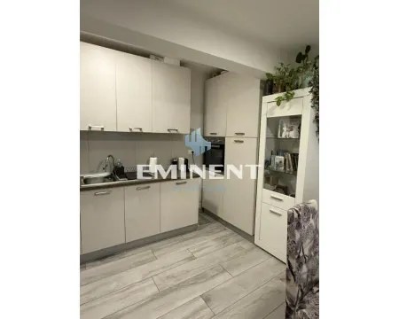 Kitchen with light wood cabinets and white display units. - image 7