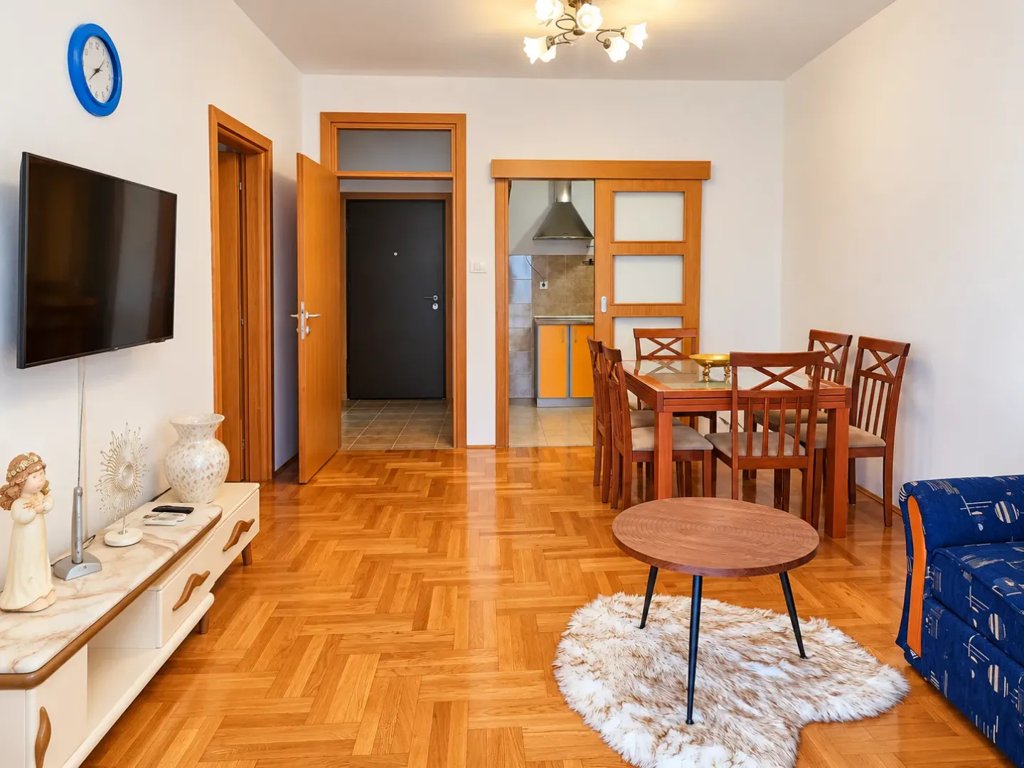 Spacious living room with dining area and parquet flooring.