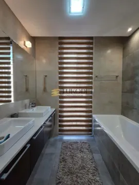 Modern bathroom equipped with two washbasins, a bathtub, and a window with blinds. - image 23