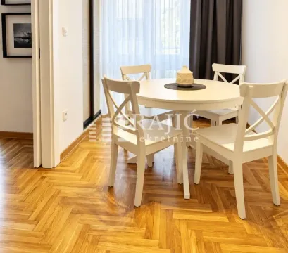 Trpezarija sa belim okruglim stolom i stolicama. - image 4