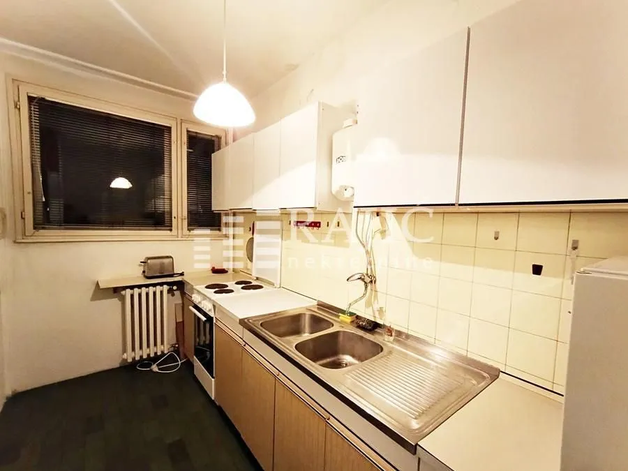 Smaller kitchen with white cabinets and a window.