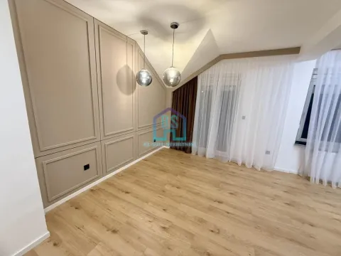 Prazna soba sa drvenim podom, dekorativnim zidnim panelima i visećim lampama. - image 6