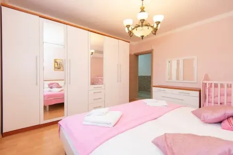 Spavaća soba sa velikim bračnim krevetom, bijelim garderoberom i roze posteljinom. - image 17