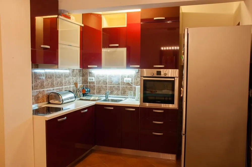 Kitchen with red cabinets and built-in appliances.