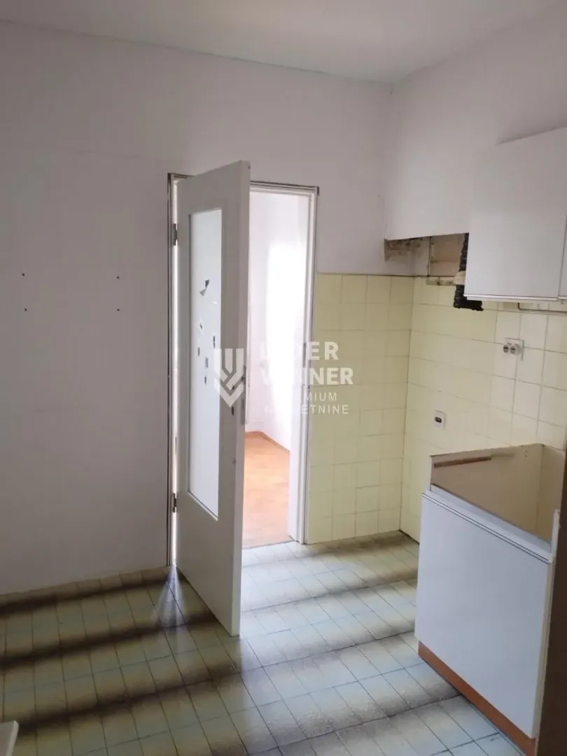 Empty kitchen with wall and floor tiles.