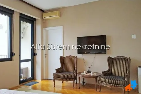Dnevna soba sa dve fotelje, stočićem i televizorom na zidu. - image 12