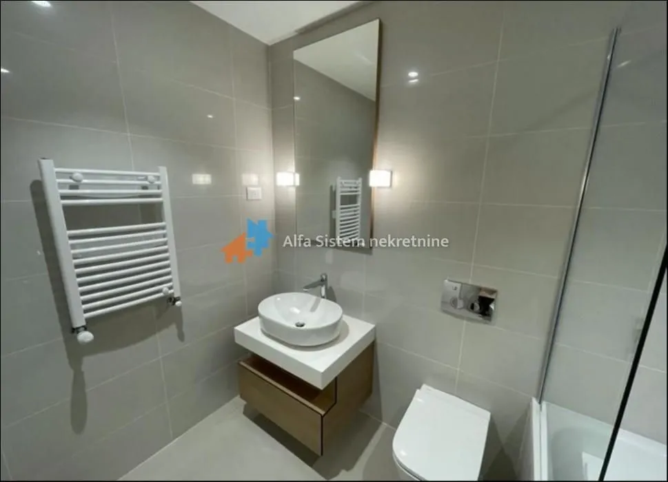 Modern bathroom with a washbasin, mirror, and light-toned sanitary fixtures.