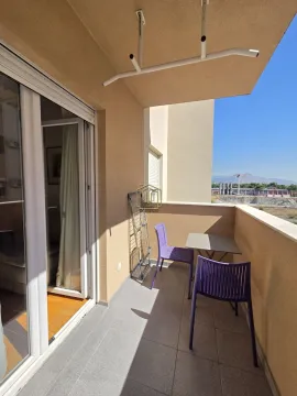 Natkriveni balkon sa garniturom za sjedenje i pogledom na okolinu. - image 10
