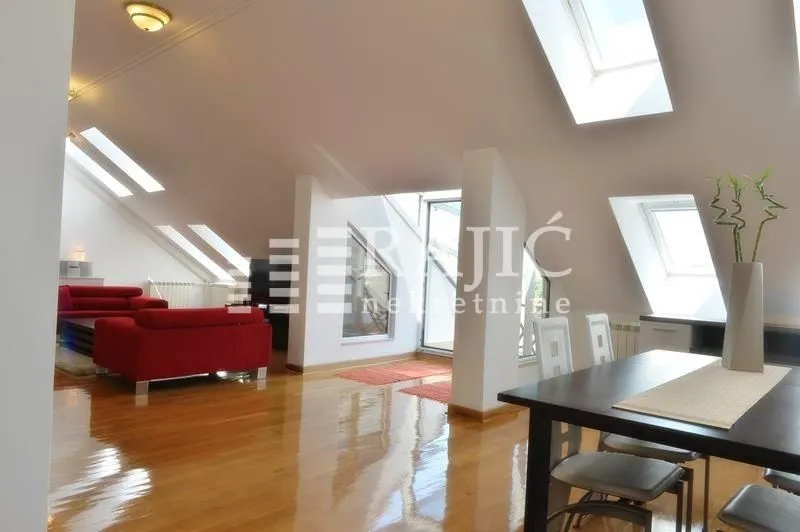Spacious attic living room with dining area and skylights.