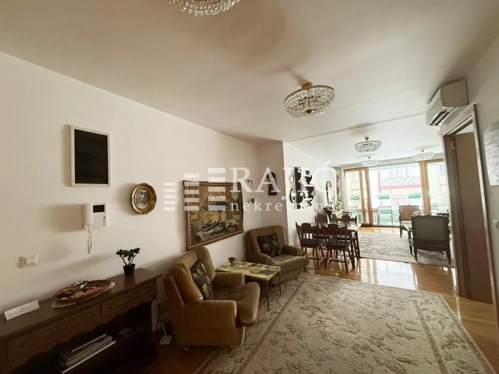 Spacious living room with seating furniture and a dining area in the back.