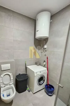 Modern bathroom with a walk-in shower, toilet, washing machine, and water heater. - image 8