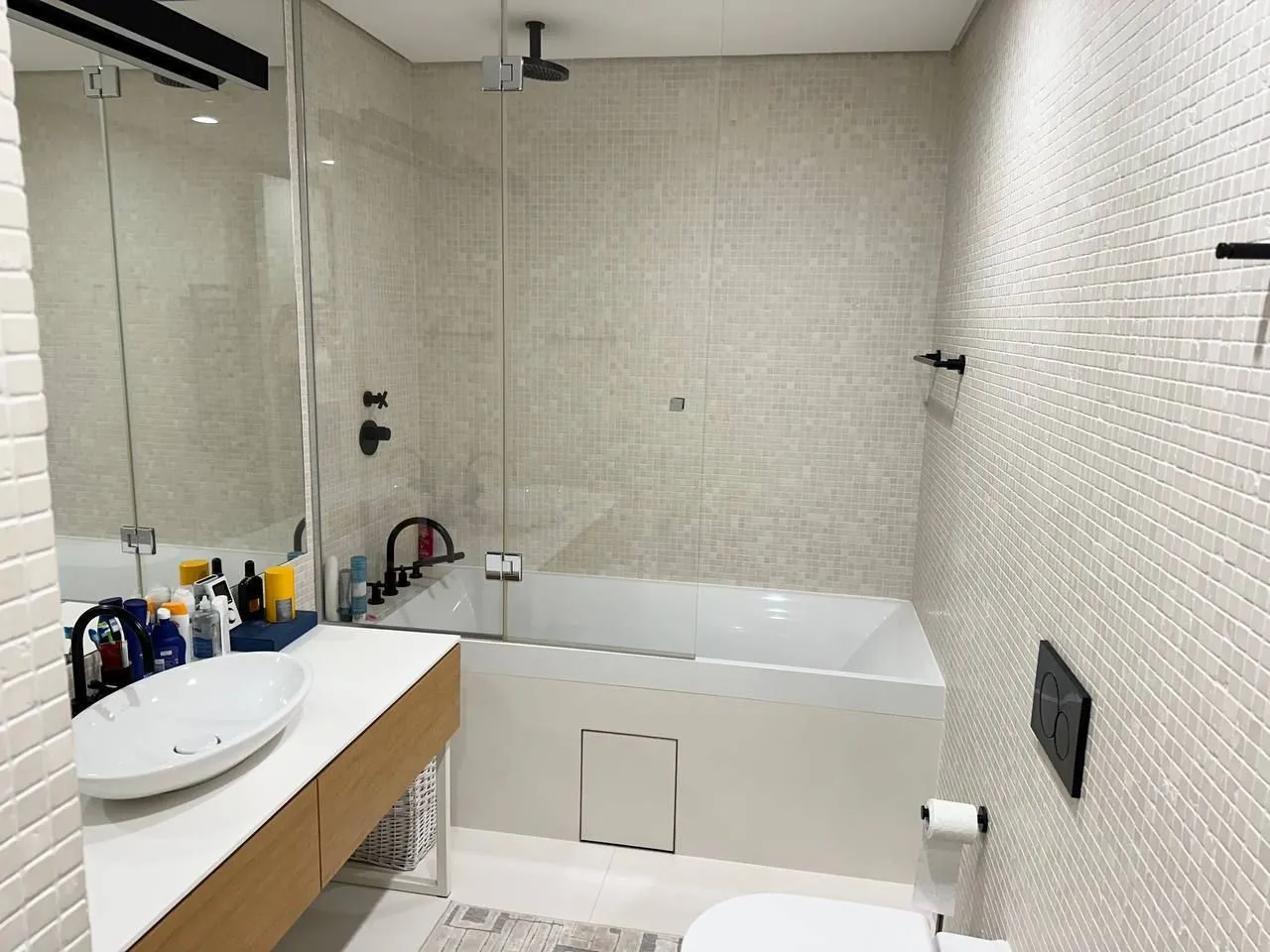 Modern bathroom with a bathtub, shower, and washbasin.