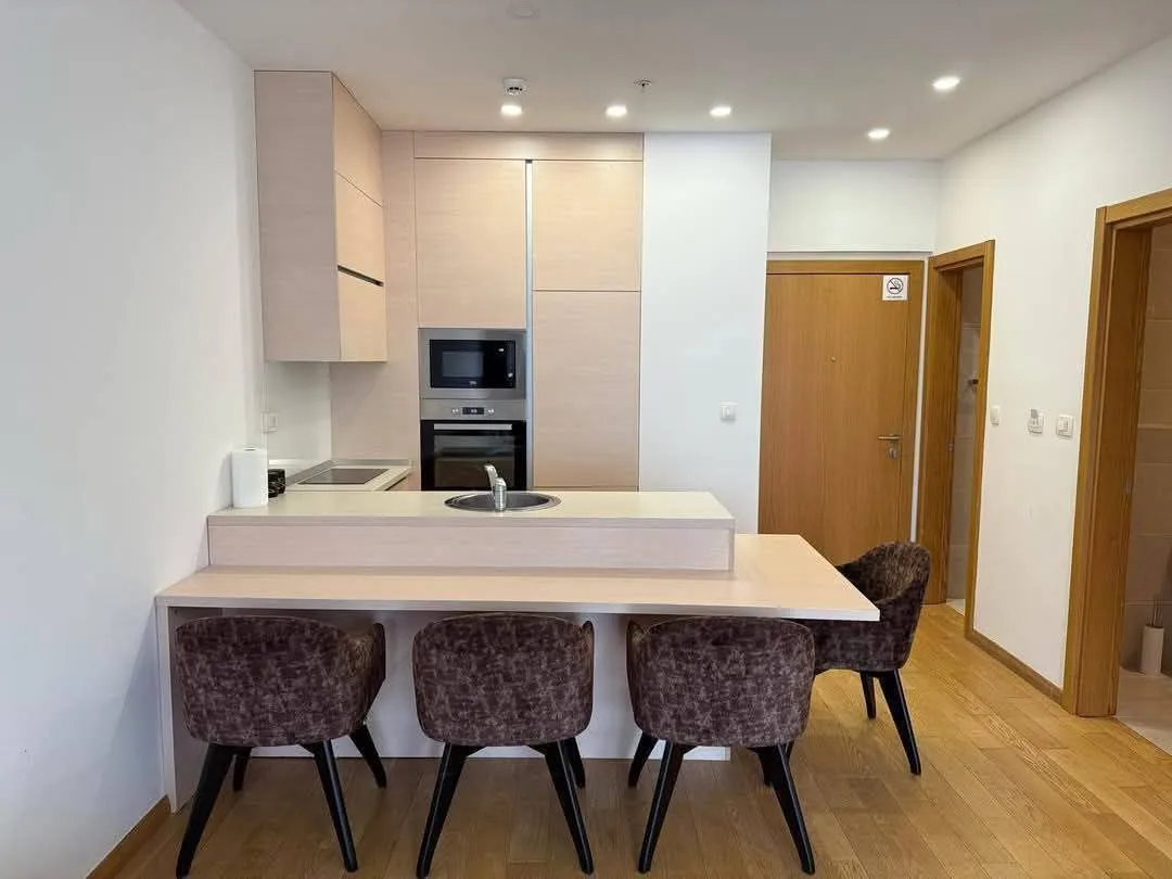 Modern kitchen with a breakfast bar and dining chairs.