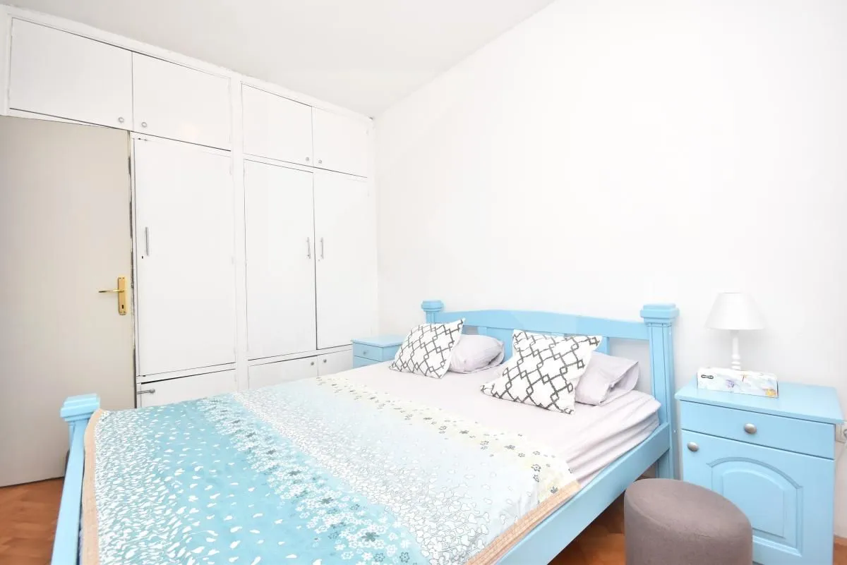 Bedroom with a blue bed and built-in wardrobe.