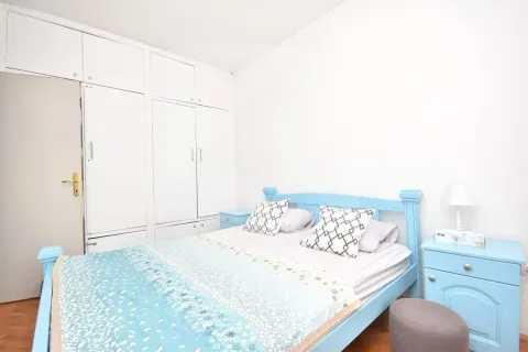 Bedroom with a blue bed and built-in wardrobe. - image 7