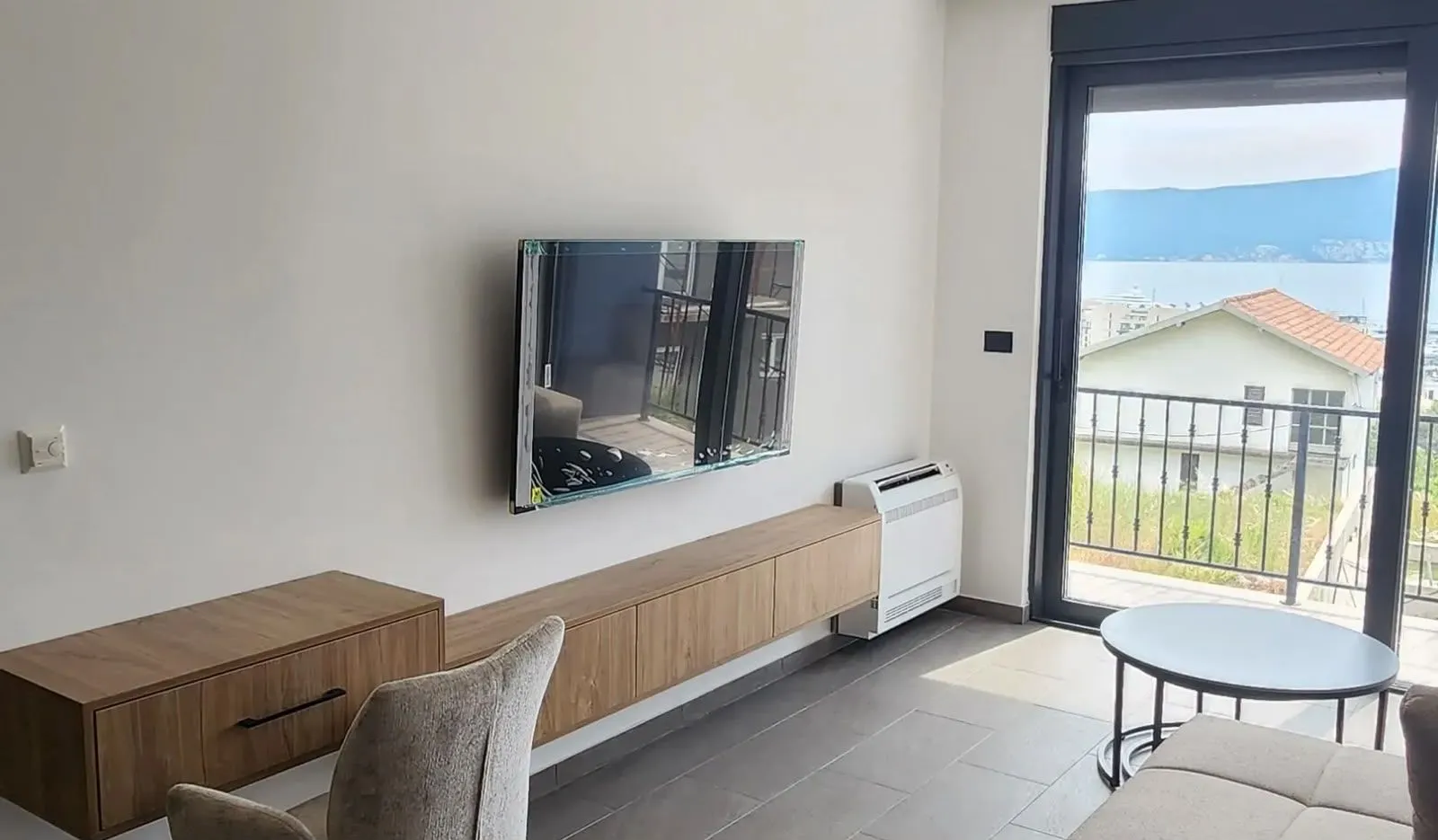 Living room with a wall-mounted TV and access to the terrace.
