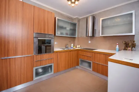 Modern kitchen with wooden cabinetry and built-in appliances. - image 4