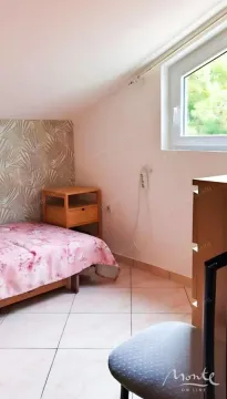 Manja spavaća soba sa krevetom i prozorom pod krovnim kosinama. - image 9