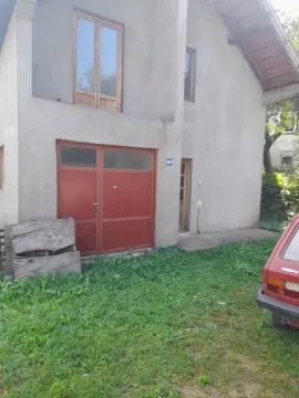 View of the exterior of the house with a yard and garage doors. - image 2