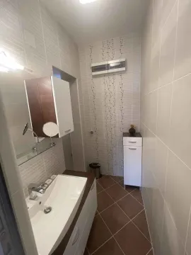 Pogled na kupatilo sa umivaonikom, ogledalom i pločicama. - image 12