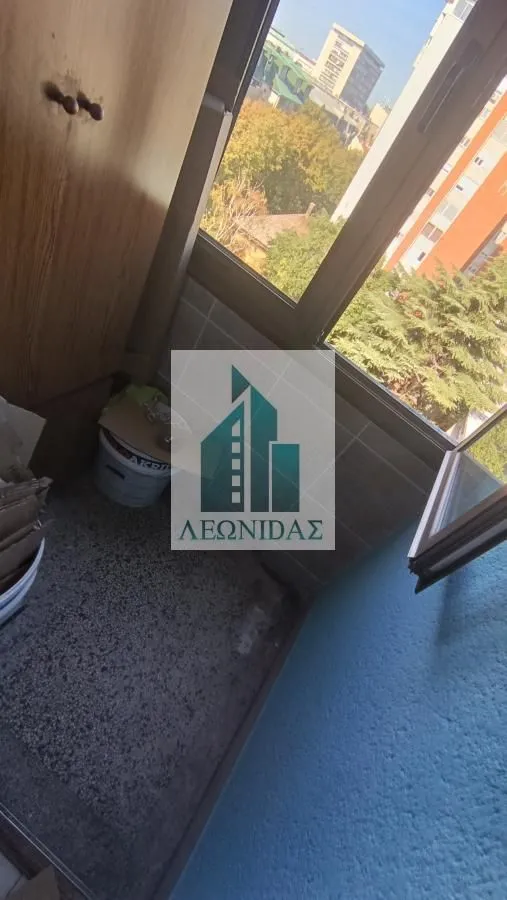 Small enclosed balcony space with a window and a city view.