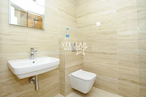 Modern bathroom tiled in beige with a washbasin and a wall-hung toilet. - image 3