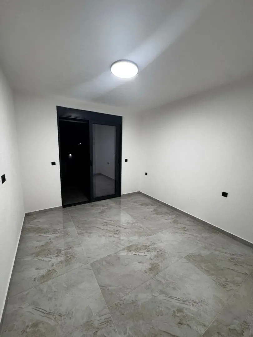 Empty room with ceramic floor tiles and access to the terrace.