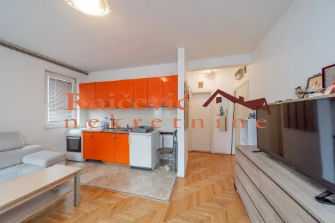 Small kitchen with orange cabinets connected to the living room. - image 16