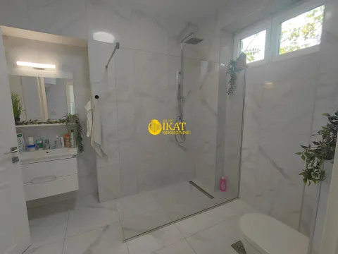 Modern bathroom with a walk-in shower, washbasin, and toilet. - image 3