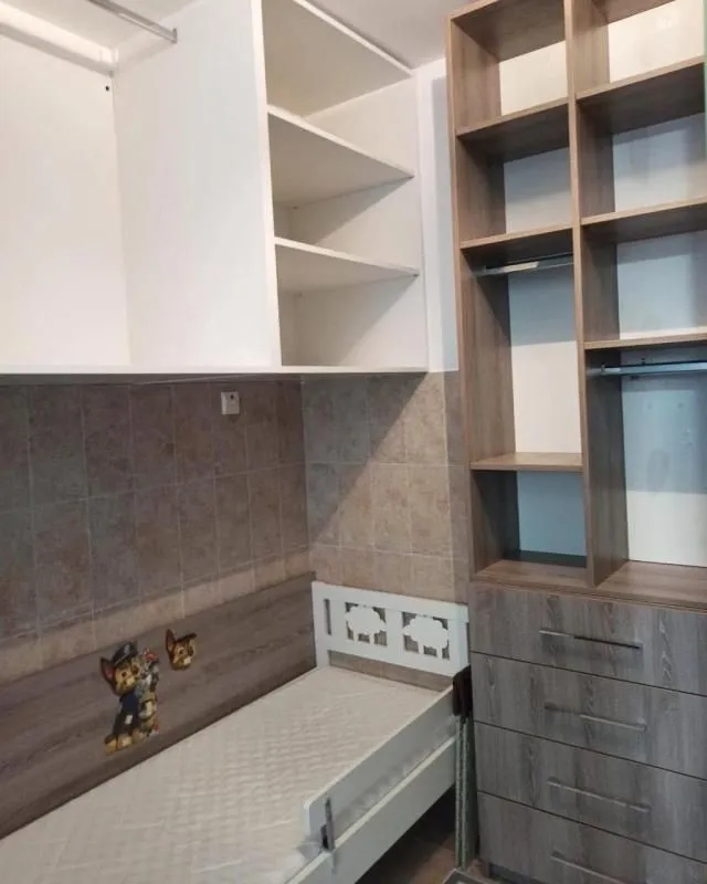 Children's bedroom with a bed and built-in closets.