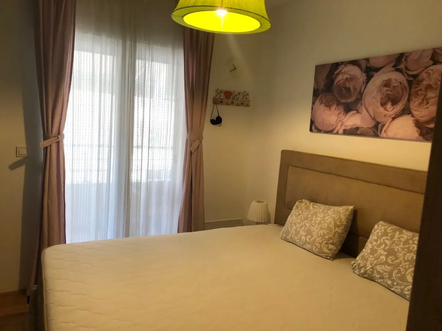 Bedroom with a double bed and a window with curtains.