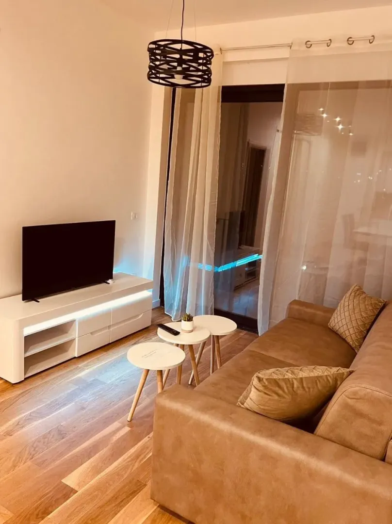 Dnevna soba sa garniturom, TV komodom i stočićem.