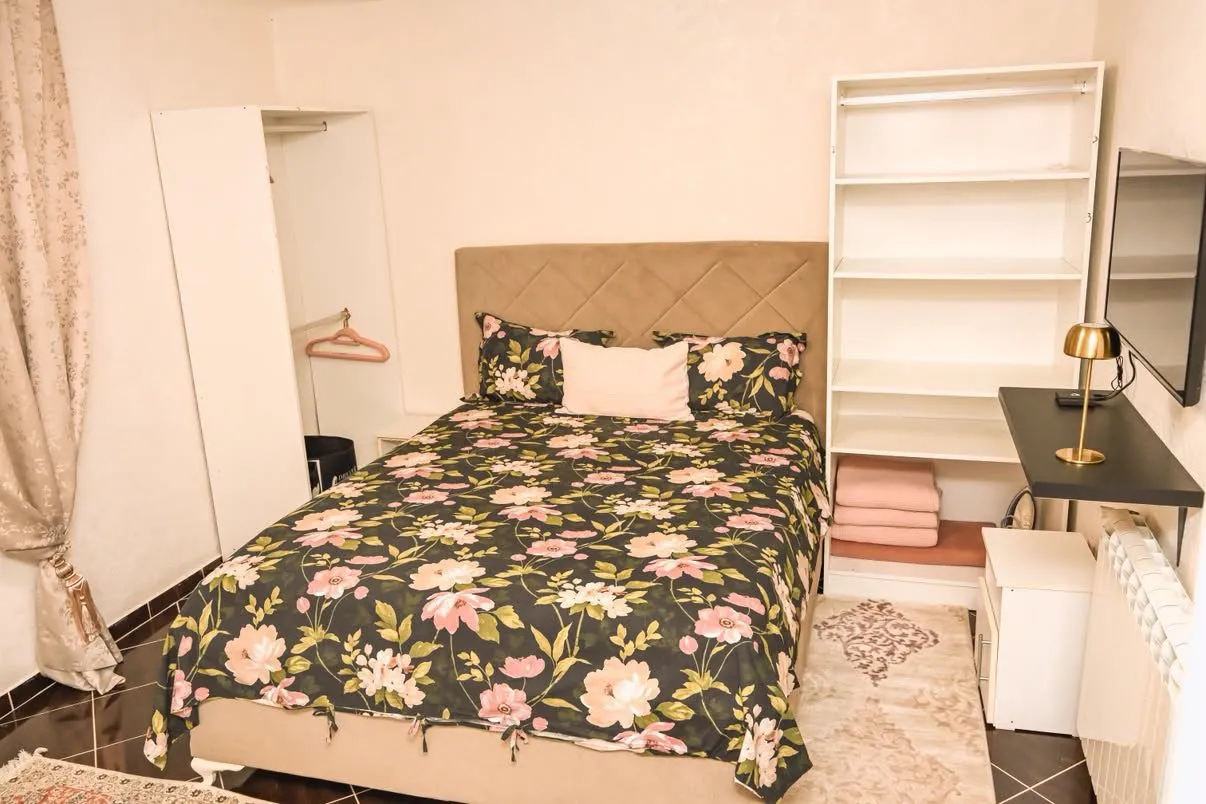 Furnished bedroom with a double bed, wardrobe, and desk.