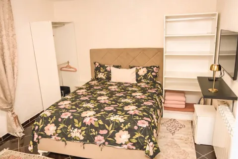 Furnished bedroom with a double bed, wardrobe, and desk. - image 10