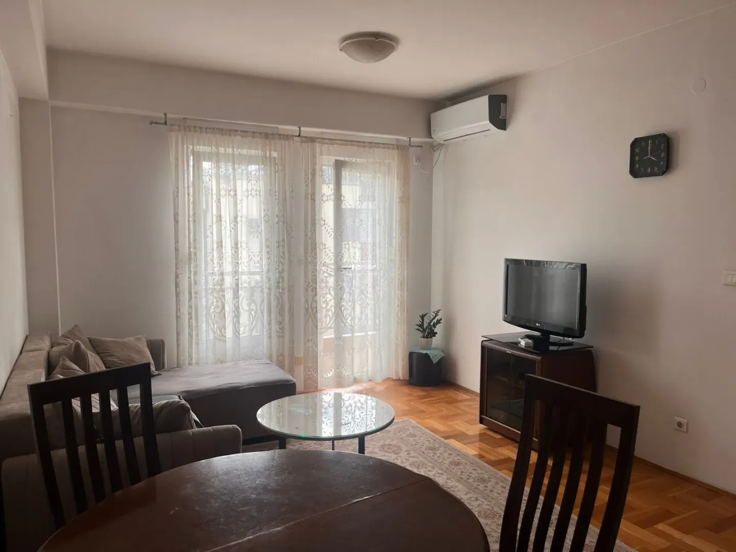 Living room with a sofa, TV, and dining table.