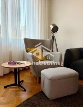 Comfortable armchair with an ottoman and a small table in the living room. - image 4