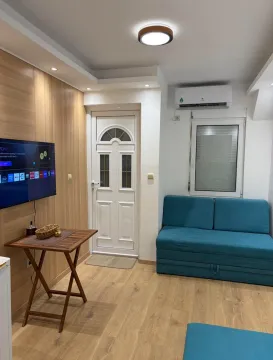 Dnevna soba sa garniturom, televizorom i drvenim panelima. - image 7