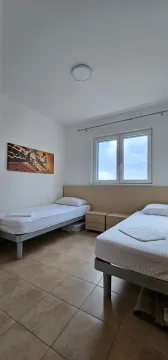 Svjetla spavaća soba sa dva kreveta za jednu osobu i prozorom. - image 12