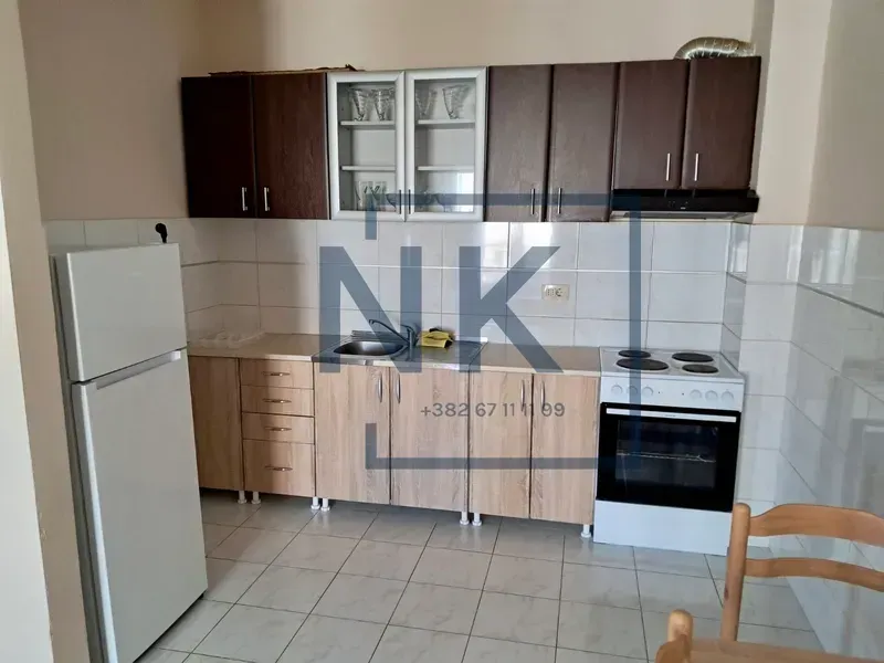 Small kitchen with wooden cabinets, refrigerator, and stove.