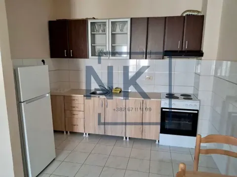 Small kitchen with wooden cabinets, refrigerator, and stove. - image 3