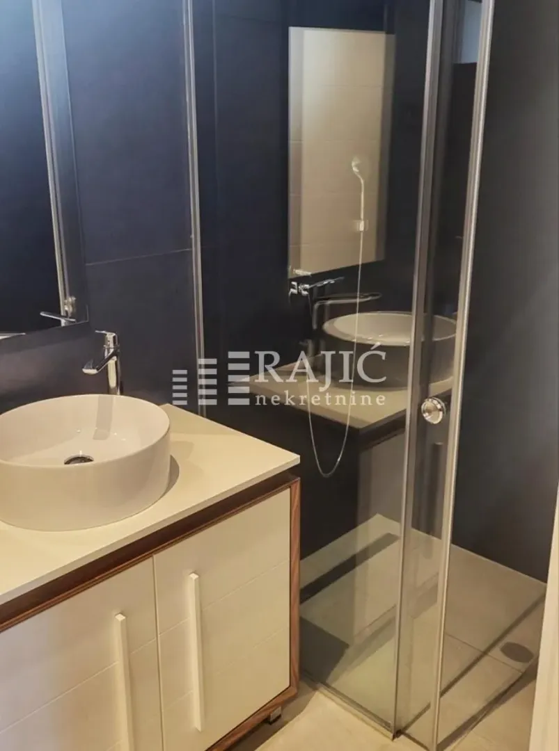 Modern and tidy bathroom with a washbasin and walk-in shower.